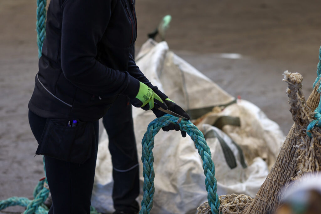 Conversation with Circular Innovators: Nofir’s Andreas Nordvik on Transforming Aquaculture Waste into a Circular Opportunity Worker collecting discarded fishing nets and ropes for recycling.